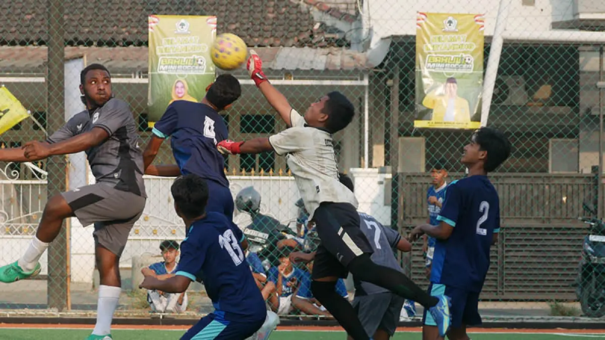 BEREBUT DI UDARA: Pemain SMAN Rambipuji Yunus Fefanya Babingga (kiri), berebut bola atas dengan kiper SMKN 2 Jember dalam pertandingan semifinal Bahlil Mini Soccer Zona 10 Jember, Jumat sore (2/10). Pertandingan itu dimenangkan SMAN Rambipuji dengan skor 2-1. (Foto: Sidkin Ali/Jawa Pos Radar Jember)