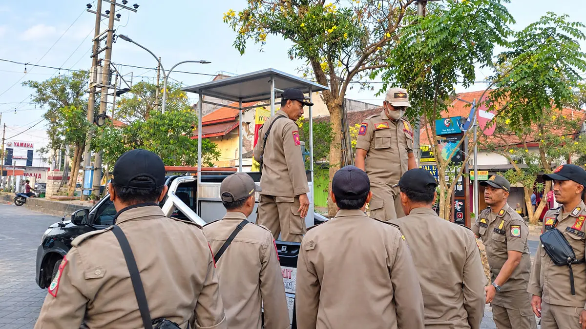 DITERTIBKAN: Jajaran personel Satpol PP saat mengamankan salah satu stan PKL yang jualan di trotoar.