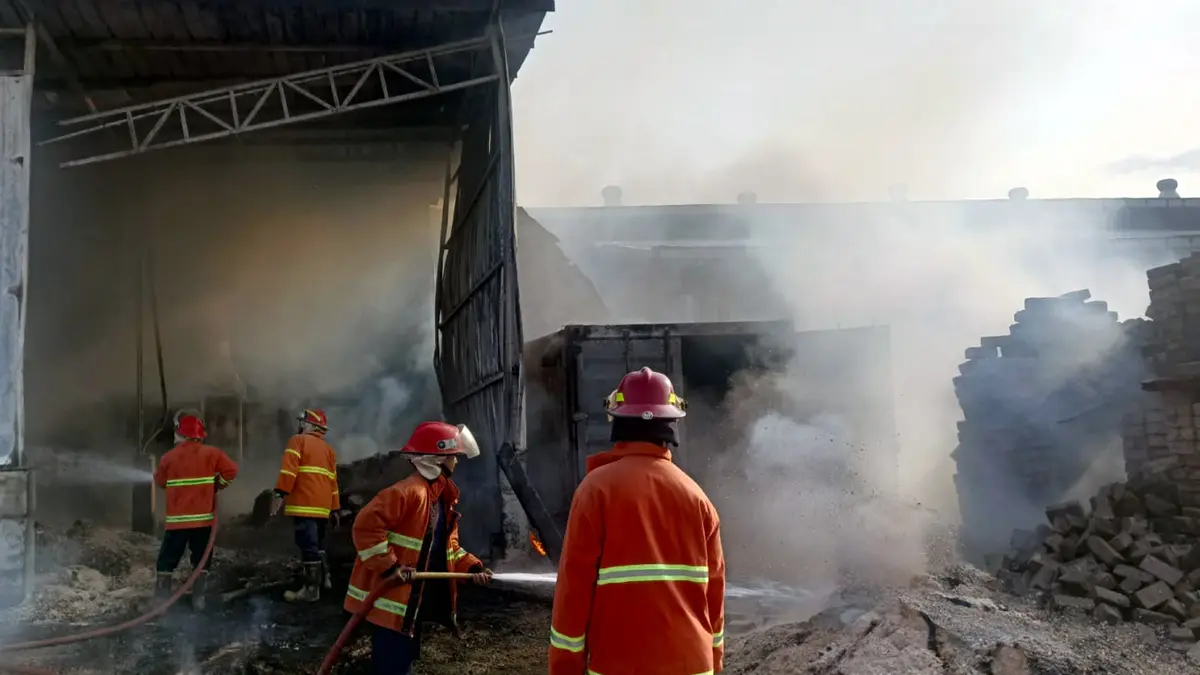 Petugas damkar saat berupaya memadamkan api yang melalap pabrik kayu di Karangketug, Gadingrejo, Kota Pasuruan, Rabu sore (7/10).