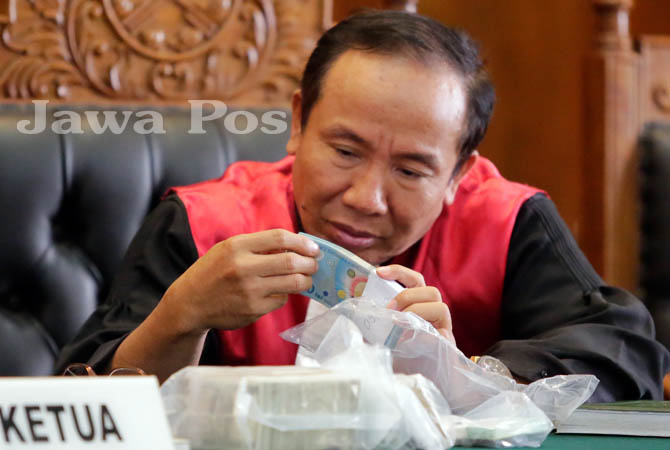 dwi purwadi (hakim anggota) saat melihat barang bukti uang milik kanjeng dimas kasus penggandaan uang - galihcokro/jawapos