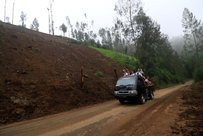 Serombongan murid SDN Baledono sedang melintas di jalan lokasi longsor di Desa Baledono, Kecamatan Tosari, Kabupaten Pasuruan, Selasa (30/4/2019) siang.