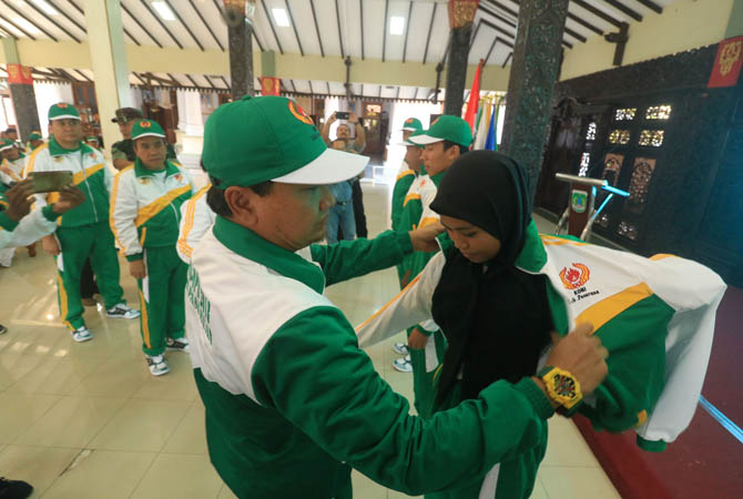 Bupati Pasuruan HM Irsyad Yusuf mengenakan jaket olahraga secara simbolis kepada salah satu peserta kontingin saat acara pelepasan kontingen Porprov Jatim VI 2109 di Pendopo Bupati, Jumat (28/6) siang.