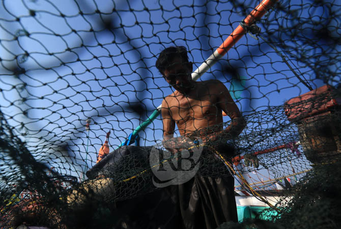 Maksum (55) nelayan Desa Jatirejo, Kecamatan Lekok, Kabupaten Pasuruan, sedang memperbaiki jala ikan miliknya, Minggu (30/6) siang. Kondisi ombak besar dampak angin musim timur membuat para nelayan setempat terpaksa mencari ikan di tepian laut. Akibatnya,