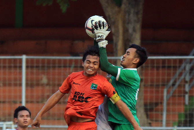Striker Persekabpas Riko berebut bola dengan kiper PSID Jombang di laga Liga 3 Zona Jawa di lapangan stadion R Sudrasono Bangil, Jumat (29/11/2019) sore. Kedudukan imbang dengan skor 2-2.