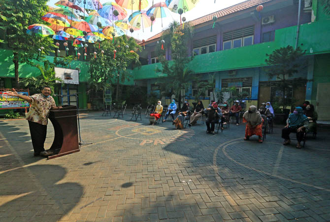 Kepsek SMPN 3 Kota Pasuruan, Agung Arditigo memberikan sambutan kepada sejumlah wali sisiwa yang hendak mengambil surat kelulusan siswa, Selasa (9/6/2020) pagi.