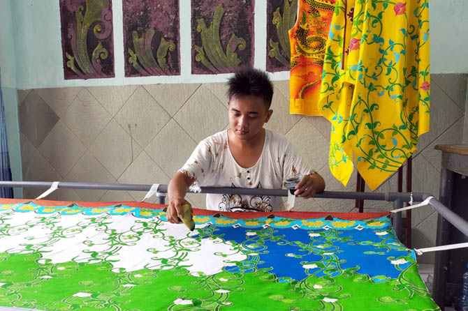 TELITI: M Hidayah Jati saat melakukan proses pewarnaan batik dengan teknik pewarnaan remasol. (Rizal Syatori/ Radar Bromo)