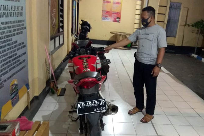 BARANG BUKTI: Anggota Polsek Kademangan, menunjukkan sepeda motor yang ditemukan warga di area pesawahan Kelurahan Triwung Kidul. (Istimewa)