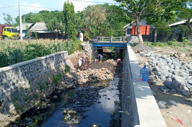DIPERBAIKI: Pekerja saat membenahi saluran irigasi di Jalan Gajah Mada. (Foto: Istimewa)