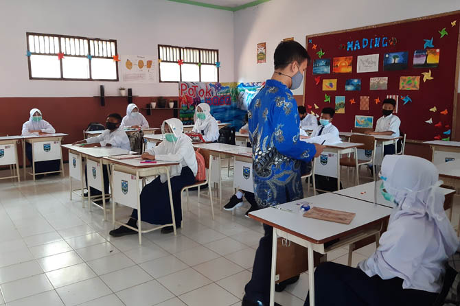 TERAPKAN PROKES: Proses kegiatan belajar mengajar sistem tatap muka di salah satu SMPN di Lumbang. (Foto: Arif Mashudi/Jawa Pos Radar Bromo)