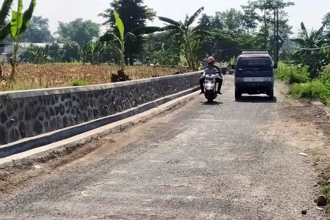 SEMAKIN BAIK: Pengendara motor melintas di ruas jalan kabupaten di Dusun Lawatan-Babatan, Desa Mojotengah, Kecamatan Sukorejo, Kabupaten Pasuruan, yang kini makin nyaman dilintasi. (Foto: Rizal Fahmi Syatori/Jawa Pos Radar Bromo)