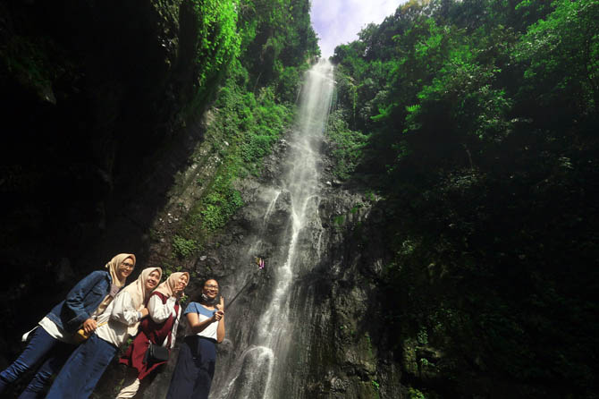 WILAYAH PERHUTANI: Wisatawan menikmati air terjun Putuk Truno di Kelurahan/Kecamatan Prigen. (Foto: M Zubaidillah/Jawa Pos Radar Bromo)