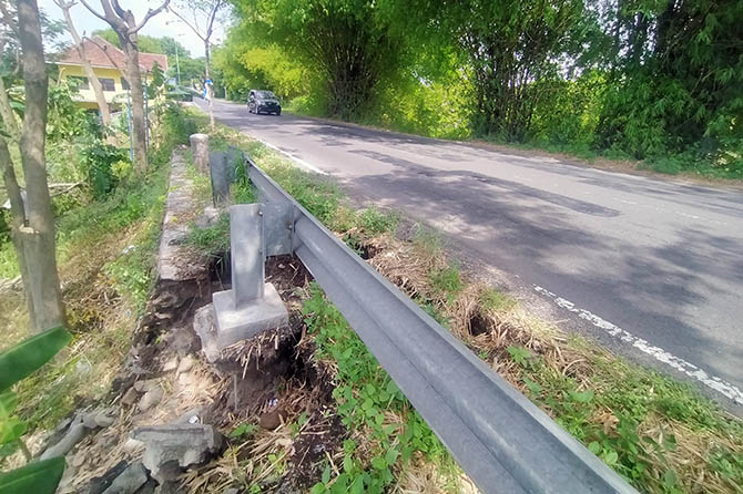 BELUM DIPERBAIKI: Kondisi ruas tepi jalan raya Bangil-Pandaan di Desa Kenep, Kecamatan Beji yang sudah beberapa bulan ini ambrol dan belum diperbaiki. (Iwan Andrik/Radar Bromo)