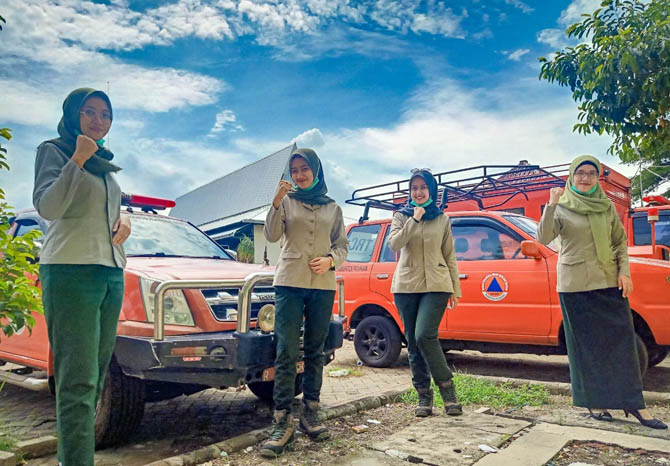 KIRI-KANAN: Zendra Mahar Qoissla Esthu - Fitria Nur Fita - Audita Kharisma - Clara Fitria di depan armada BPBD. (Foto: Erri Kartika/Jawa Pos Radar Bromo)