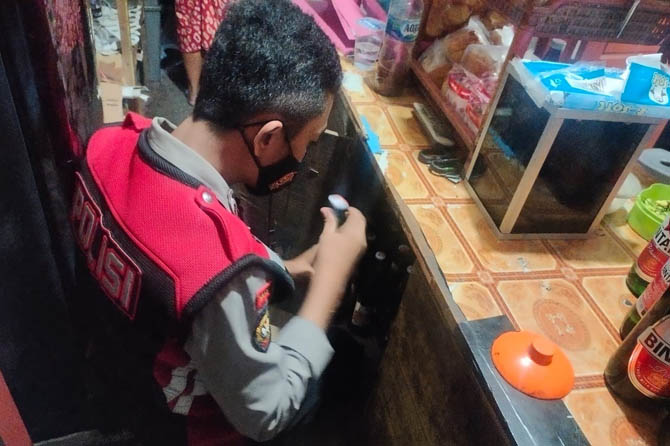 KOTAK RAHASIA: Anggota Sabhara Polres Probolinggo, mendapati ratusan botol miras di warung kopi milik Slamet, warga Desa Tamansari, Kecamatan Dringu, Senin (30/11) pagi. (Foto: Istimewa)