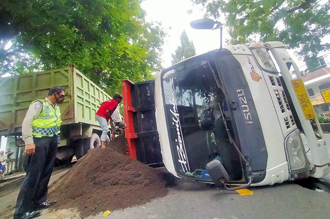 HILANG KENDALI: Truk muat pasir yang terguling di Pagak, Beji, Rabu (30/12) pagi. (Iwan Andrik/Radar Bromo)