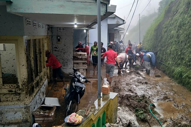 GOTONG ROYONG: Warga gotong royong membersihkan material longsor dipenuhi lumpur yang menimpa rumah warga di Tosari, kemarin. (BPBD Kabupaten Pasuruan for Jawa Pos Radar Bromo)