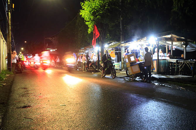 MASIH RAMAI: Sejumlah PKL kembali berjualan di pinggir jalan di belakang pabrik PT Eratex, Jumat (15/1) petang. Mereka bertahan di lokasi itu karena dinilai lebih ramai dibanding lokasi baru. Yaitu, RTH Brantas. (Zainal Arifin/Radar Bromo)