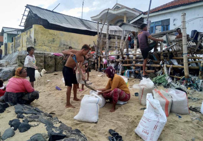 PORAK PORANDA: Tanggul yang jebol di sekitar pemukiman rumah warga di Pulau Gili Ketapang. Usai insiden tersebut, warga membuat tanggul darurat dari karung berisi pasir. (Foto: Pemdes Ketapang for Jawa Pos Radar Bromo)