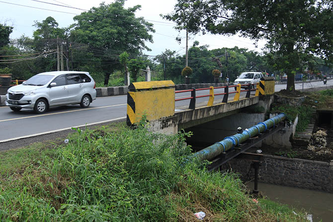 BAKAL DIPERBAIKI: Sejumlah pengendara melintas di jembatan Latek, Bangil. Tahun ini jembatan setempat bakal direhab landasan dan kaki-kakinya dengan konstruksi box culvert. (Foto: Mokhamad Zubaidillah/Jawa Pos Radar Bromo)