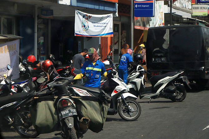 SUMBANG PAD: Petugas jukir menata parkir di areal Pandaan. Tahun ini, retribusi PAD parkir mampu lampaui target evaluasi. (Mokhamad Zubaidillah/Radar Bromo)