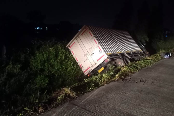 HILANG KENDALI: Kondisi truk tronton saat nyemplung parit di tol Gempol-Pandaan, Sabtu malam. (PT Jasamarga Tol for Jawa Pos Radar Bromo)
