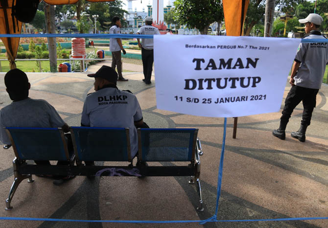 CEGAH KERUMUNAN: Sejumlah petugas berjaga di Alun-alun Kota Pasuruan di Jalan Alun-alun Selatan, Kecamatan Panggungrejo. Semua taman perkotaan, termasuk taman di alun-alun ditutup dua pekan untuk menghindari kerumunan. (Foto: Mokhamad Zubaidillah/Jawa Pos