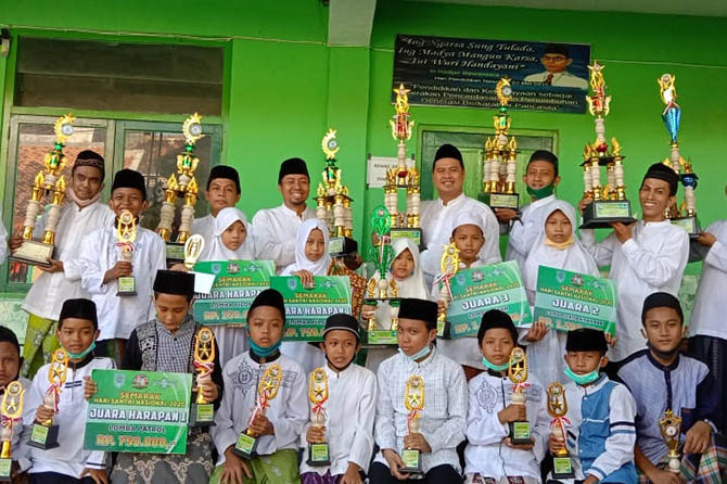 KEBANGGAAN: Sejumlah guru dan pelajar MI Kahasri, menunjukkan piala yang diperoleh dari beragam perlombaan selama 2020. (MI Kahasri for Jawa Pos Radar Bromo)