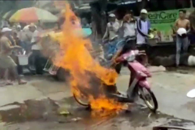 BIKIN PANIK: Warga berupaya memadamkan api yang melalap motor Yamaha Mio milik Yani, (9/2). (Foto Istimewa)