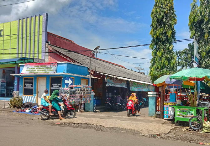 AKSES MASUK: Beberapa pengunjung melintas di pintu gerbang Pasar Maron Minggu (21/2) pagi. Dishub berencana memberi portal parkir otomatis untuk meningkatkan keamanan dan ketertiban arus lalu lintas kendaraan. (Foto: Achmad Arianto/Jawa Pos Radar Bromo)