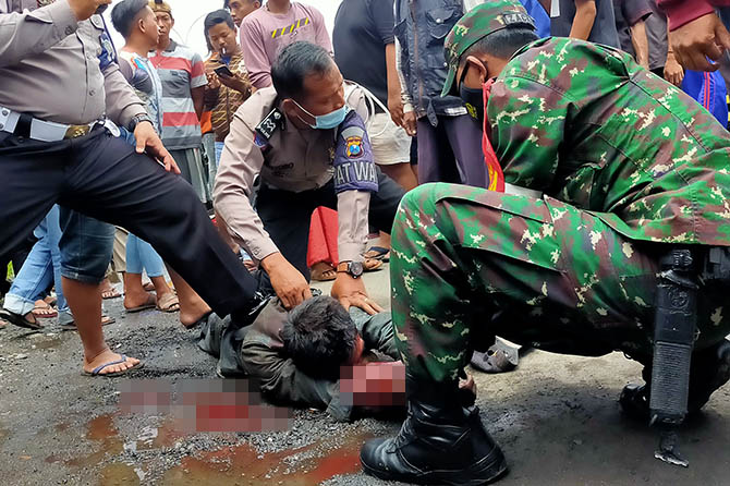 MASIH DIPROSES: Petugas saat mengamankan M Musthofa yang berupaya kabur. Sambil menunggu surat dari RSJ, pelaku saat ini masih ditahan di Polsek Rembang. (Jawa Pos Radar Bromo Photo)