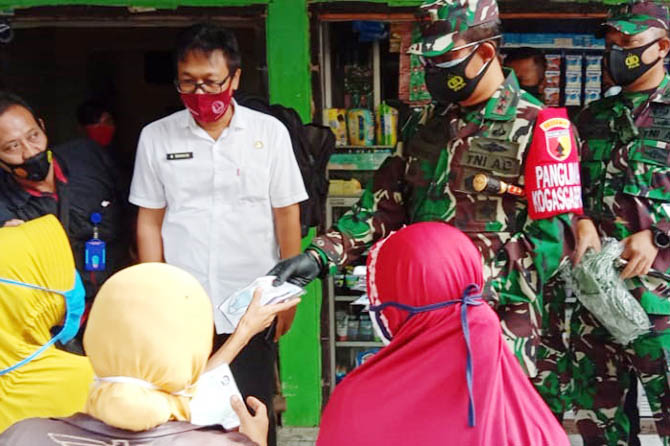 LIHAT LANGSUNG: Pangdam V Brawijaya Mayjen TNI Suharyanto, memberikan masker kepada salah seorang pedagang di Pasar Kebonagung, Kota Pasuruan, Sabtu (6/2). Fahrizal Firmani/Jawa Pos Radar Bromo)
