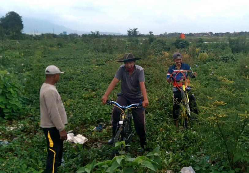 SEPERTI PULAU: Beberapa warga bersepeda di atas Sungai Wrati di Desa Kedungringin, Kecamatan Beji, Kabupaten Pasurun. Saat ini endapan di sungai tersebut begitu tebal. Bahkan, bisa dipakai bersepeda dan jalan-jalan. (Foto: Istimewa)