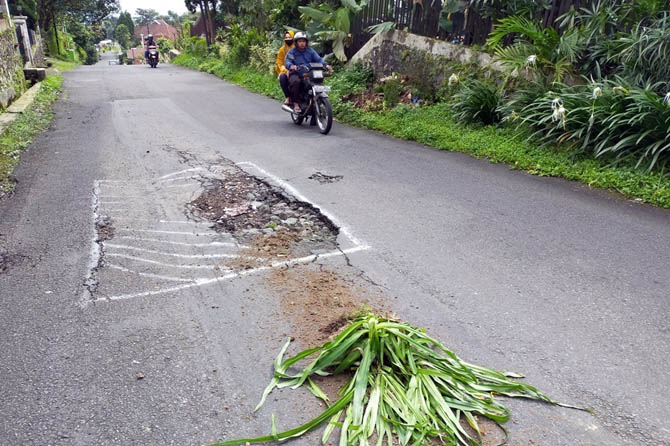 MEMBAHAYAKAN: Kondisi jalan berlubang di tanjakan Jerapah, Kelurahan/Kecamatan Prigen yang memicu banyak korban berjatuhan. (Rizal Syatori/ Radar Bromo)