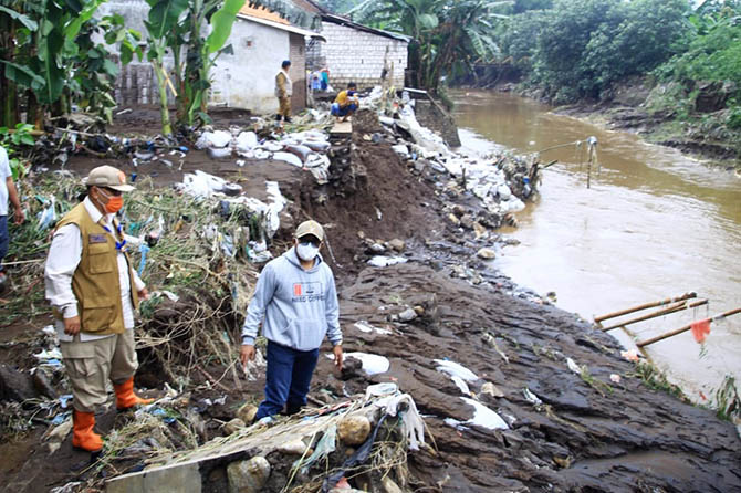 MAKIN PARAH: Kerusakan tanggul di Dusun Gandean RT 2/ RW I, Desa Dringu, makin parah saat banjir susulan terjadi, Minggu (28/2). Saat ini tanggul jebol sepanjang 100 meter dari awalnya 30 meter. (Arif Mashudi/Radar Bromo)