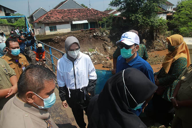 BANTU SEMBAKO: Bupati Probolinggo P. Tantriana Sari didampingi suaminya, Hasan Aminuddin yang juga wakil ketua Komisi IV DPR RI, meninjau lokasi banjir di Desa/Kecamatan Dringu, Senin (8/3). (Arif Mashudi/Radar Bromo)
