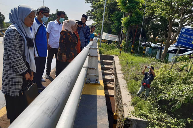 TINJAU SUNGAI: Anggota Komisi VIII DPR RI meninjau Sungai Kedunggaleng dari jembatan di Jalan Raya Wonolangan, Kecamatan Dringu, Jumat (12/3). Komisi VIII mendesak penggunaan BTT APBN untuk membantu pemulihan infrastruktur yang rusak. (Arif Mashudi/Radar