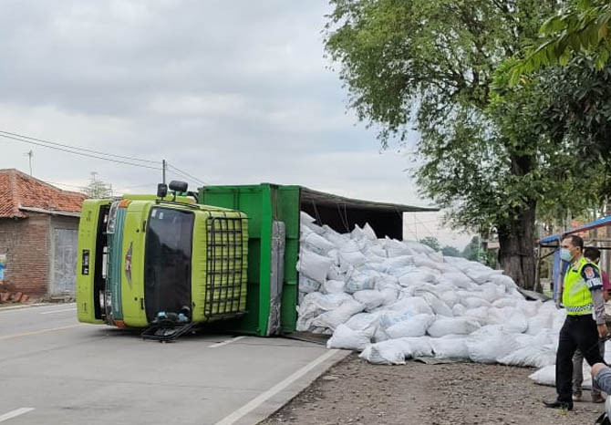 TUTUPI JALAN: Truk yang memuat batu apung, yang terguling di Jalan raya Pantura, Gending, Senin (22/3) pagi. (Foto: Fatah for Jawa Pos Radar Bromo)