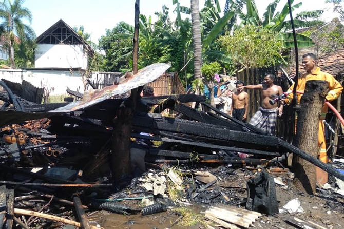 HANGUS: Sejumlah warga melihat dari dekat puing-puing kandang sapi milik Suhud, warga Desa Karanganyar, Kecamatan Paiton, yang terbakar, Rabu (24/3). (Agus Faiz Musleh/Jawa Pos Radar Bromo)
