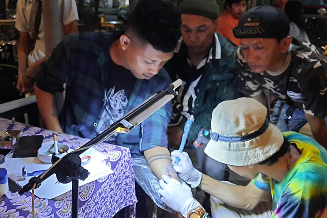 MANUAL: Gaya Niko saat menato kliennya. (Foto: Fahrizal Firmani/Jawa Pos Radar Bromo)