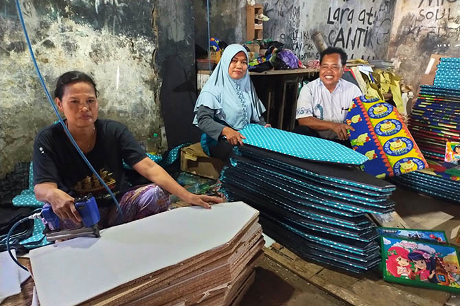 PRODUKSI: Khusnul Khotimah, 43, (tengah) menunjukkan produksi pembuatan meja setrika dan meja belajar lipat kepada Sekretaris BPD Pekoren, Kecamatan Rembang, Mujiono di rumah produksinya. (Iwan Andrik/Radar Bromo)