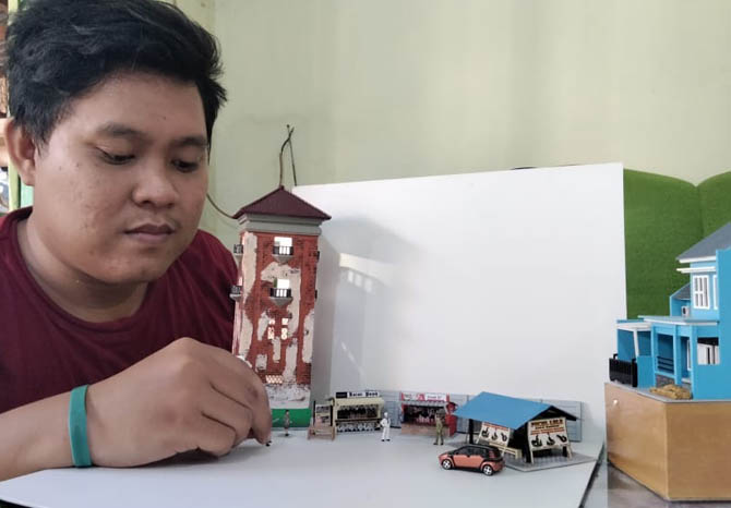 BUTUH KETELATENAN: Dedy Surya Mubarok menunjukkan diorama buatannya. Dia juga mahir membuat maket bangunan dengan skala kecil. (Foto M Busthomi/Jawa Pos Radar Bromo)