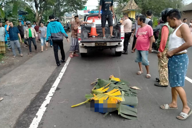 NAHAS: Petugas dan warga saat hendak mengevakuasi jenazah Vernanda Bayu Nugroho yang masih ditutup daun pisang. (Istimewa)