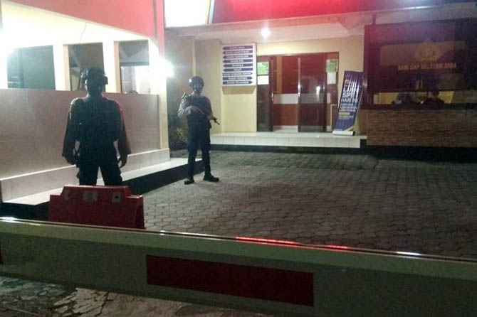 DIJAGA KETAT: Dua anggota berjaga di depan Mapolres Probolinggo Kota, Rabu (31/3) malam. Mereka dilengkapi dengan senjata laras panjang. (Rizky Putra Dinasti/Jawa Pos Radar Bromo)
