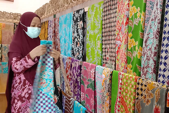 BERAGAM MOTIF: Rusyami menunjukkan beberapa motif batik tulis hasil karyanya. (Achmad Arianto/Jawa Pos Radar Bromo)