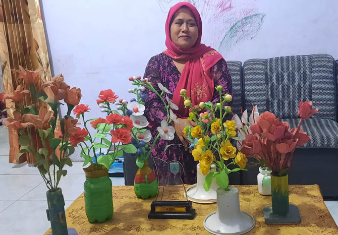 BELUM DIJUAL: Lilis Nurhayati dan kreasi bunga buatannya. (Foto: Fahrizal Firmani/Jawa Pos Radar Bromo)