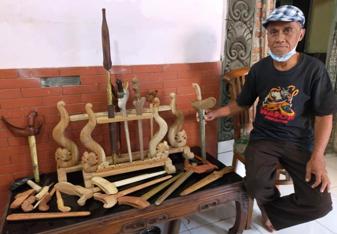 SUDAH RATUSAN: Joni Suntoro bersama kreasi werangan buatannya. (Foto: Rizal F Syatori/Jawa Pos Radar Bromo)