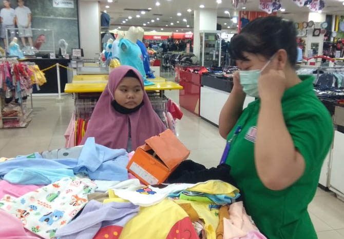 DIDAMPINGI: Salah satu anak yatim-piatu didampingi karyawan KDS saat memilih baju di toko. (Foto: Rizky Putra Dinasti/Jawa Pos Radar Bromo)