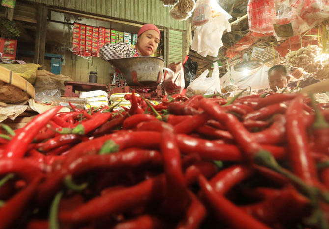 SEGAR: Pedagang bumbu di pasar besar Pasuruan, melayani pembeli. Saat ini harga cabai merah yang mengalami kenaikan. (Foto: M Zubaidillah/Jawa Pos Radar Bromo)
