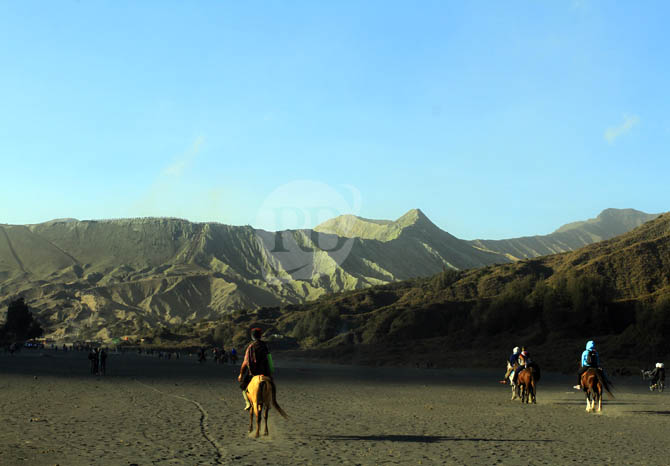 ANDALAN PROBOLINGGO: Wisatawan dan pelaku wisata berjalan di lautan pasir Bromo. Sejak dibuka mulai Senin (24/5) sejak libur Lebaran, ada ribuan pengunjung yang datang. (Foto: Zainal Arifin/Jawa Pos Radar Bromo)