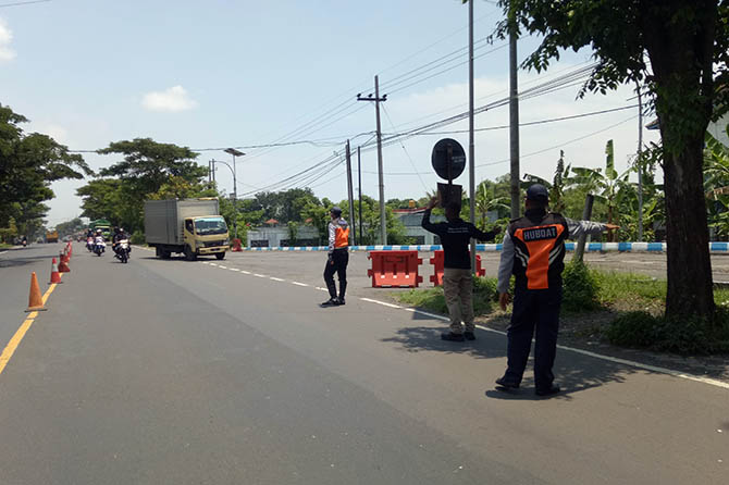 TETAP STAND BY: Petugas jembatan timbang saat mengarahkan truk muat barang masuk ke jembatan timbang Sedarum, Nguling, kemarin. Mulai hari ini, jembatan timbang berhenti beroperasi untuk sementara. Meski begitu, petugas tetap disiagakan untuk halau pemudi